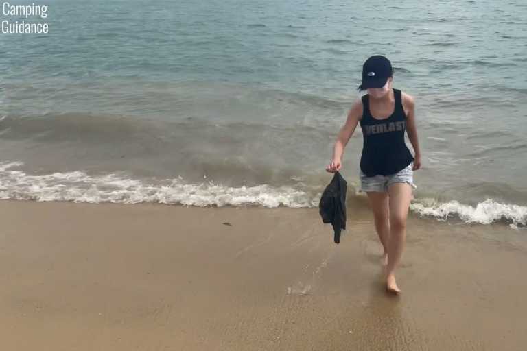 Soaking the Sea to Summit Drylite towel in seawater at a beach.