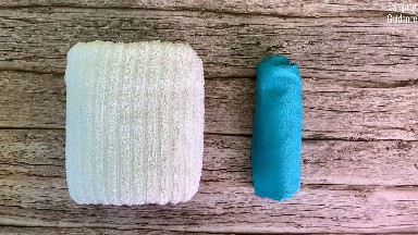 A rolled up Sea to Summit AirLite Towel beside a similar sized cotton towel.