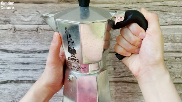 Me holding onto the handle of the Bialetti Moka Express.
