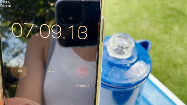 Timing how long it takes for water in the GSI Outdoors 8-Cup Enamelware Percolator to boil.