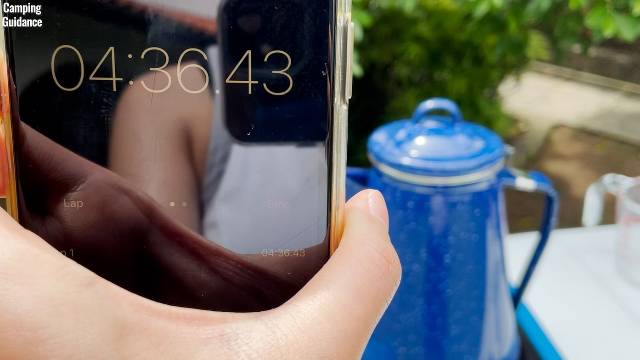 Timing how long it takes for the water to boil in the Stansport 8-Cup Enamel Percolator.