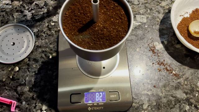 Filling the filter basket of the GSI Outdoors 8-Cup Enamelware Percolator to the brim.