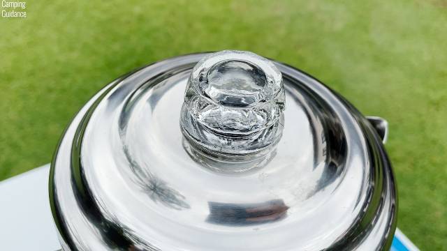 The glass perking knob of the Coleman 12-Cup Stainless Steel Percolator.