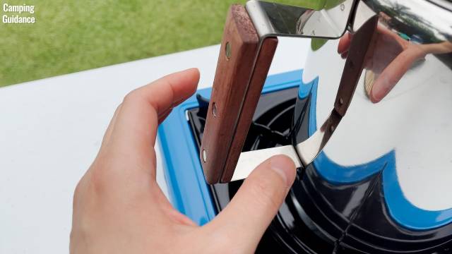 Me reaching for the rosewood handle of the Coletti Bozeman Camping Coffee Percolator.