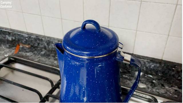 Steam coming out of the spout of the Stansport Enamel 8-Cup Percolator indoors. 