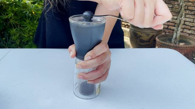 Using the Hario Mini Mill Hand Grinder to grind whole bean coffee into a coarse grind.