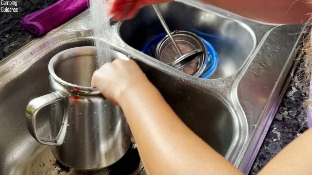 Cleaning the Coleman 12-Cup Stainless Steel Percolator by taking apart the componentry and running water through them.