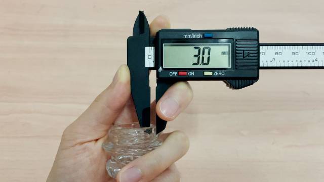 Using digital calipers to measure the thickness of the Coletti Bozeman's glass perk knob.