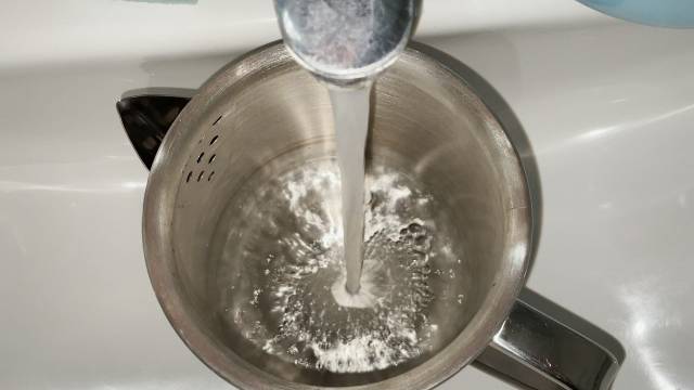 Filling up the Coleman 12-Cup Stainless Steel Percolator with tap water.