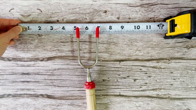 This is a picture of me measuring the distance between the tines of the Carpathen Campfire Roasting Sticks, which is about 1.75 inches or 4.5 cm.