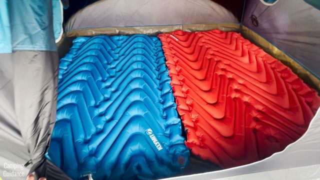 Here’s a picture of both the Klymit Uninsulated Double V (blue, left) and the Klymit Insulated Double V (red, right) look like inside a Coleman 4-Person Dome Tent.