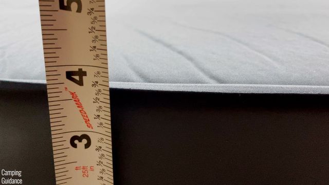 This is a picture of me measuring the thickness of the REI Camp Dreamer Double (3.75 inches).