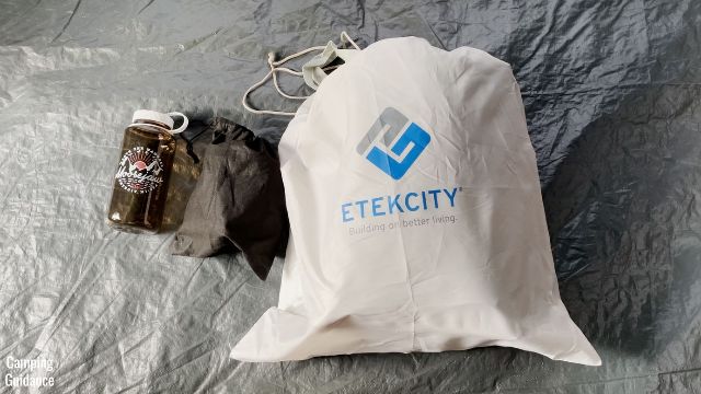 This is a picture of the rolled-up Etekcity Upgraded Camping Air Mattress beside the included pump and also a 32-ounce Nalgene bottle for a size comparison.