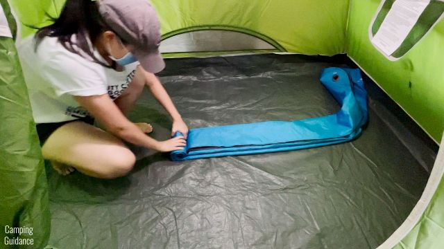 This is a picture of me rolling up the Klymit Double V Uninsulated Sleeping Pad to pack back into its stuff sack.