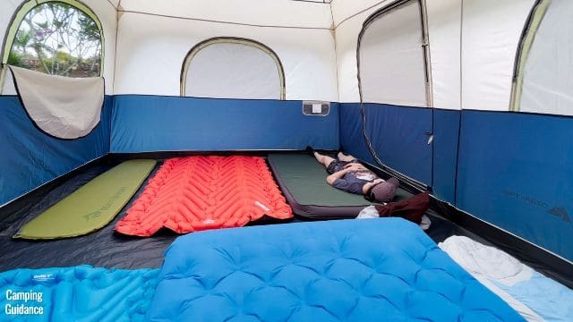 This is a picture of 10 pads in the Ozark Trail 10-Person Family Cabin Tent. There's a mix of 2 single sleeping pads, 3 double pads, and 1 full-sized mattress. That's me lying on 1 of the double sleeping pads.