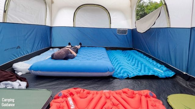 This is a picture of 10 pads in the Ozark Trail 10-Person Family Cabin Tent (this is a picture taken from the other end of the tent, the opposite end to the picture just above this). Again, there’s a mix of 2 single sleeping pads, 3 double pads, and 1 full-sized mattress. That’s me lying on the full-sized mattress.
