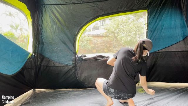 This is a picture of me unzipping the window of the back door of the Coleman 10-Person Instant Cabin Tent.