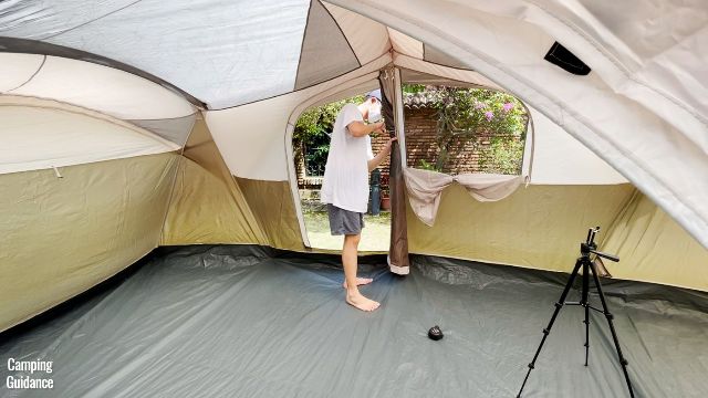 This is a picture of my brother unzipping the back door of the WeatherMaster 10-Person Tent and clipping it to the side so that it stays open.