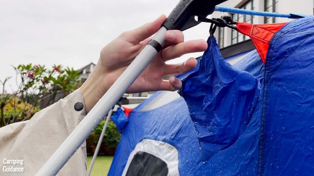 This is a picture of me attaching the steel pole with a black ring into the middle pole connector of the Columbia Mammoth Creek 10-Person Tent.