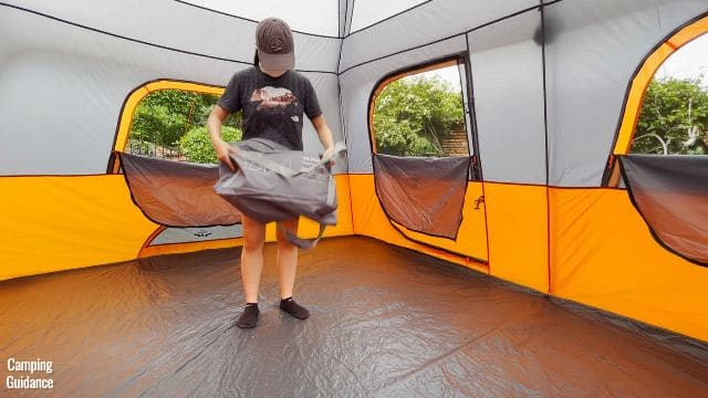 This is a picture of me holding the carry bag of the Core 10-Person Straight Wall Cabin Tent.