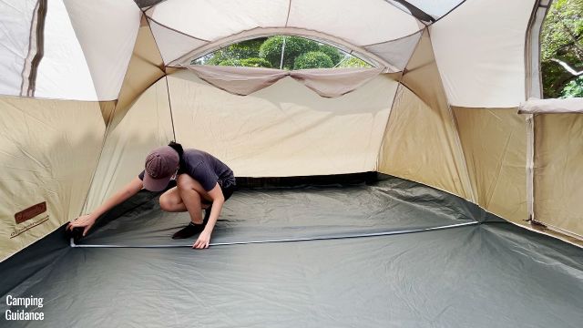 This is a picture of me using a tape measure to measure the longest width of the WeatherMaster 10-Person Tent (9 feet 1 inch).