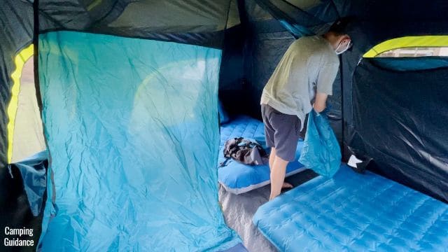 This is a picture of my brother clipping the 2 sides of the divider to the edges of the Coleman 10-Person Instant Cabin Tent.
