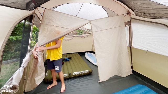This is a picture of my brother tying up the 2 sides of the divider, so that each room in the WeatherMaster 10-Person Tent can be easily accessed.