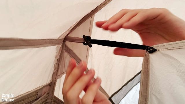 This is a picture of me securing the attachments of the divider to the loops at the sides of the WeatherMaster 10-Person Tent.