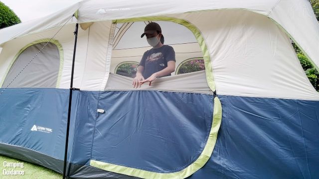 This is a picture of me opening up the bug net/window of the door of the Ozark Trail 10-Person Family Cabin Tent.
