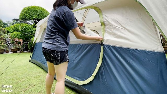 This is a picture of me trying to close the door of the Ozark Trail 10-Person Cabin Tent, while the zipper was catching on the green rain cover on the outside of the door.