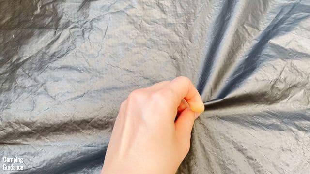 This is a picture of me pinching the polyethylene flooring of the Ozark Trail 10-Person Cabin Tent.