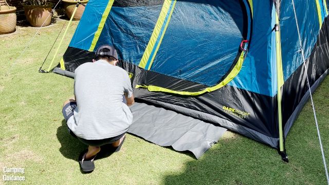 This is a picture of my brother using the stakes to stake down the provided ground sheet/floor mat of the Coleman 10-Person Instant Cabin Tent.