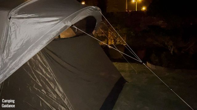 This is a picture of the guylines of the angled windows of the WeatherMaster 10-Person Tent at night.