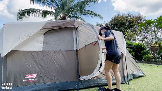This is a picture of me taking off my shoes before going into the WeatherMaster 10-Person Tent through the hinged D-door.
