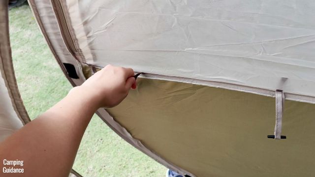 This is a picture of me closing the hinged D-door of the WeatherMaster 10-Person Tent from the inside.