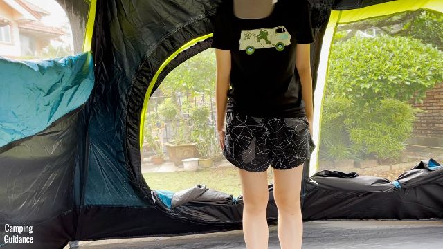 This is a picture of me standing in front of the hinged D-door on the inside of the Coleman 10-Person Instant Cabin Tent.