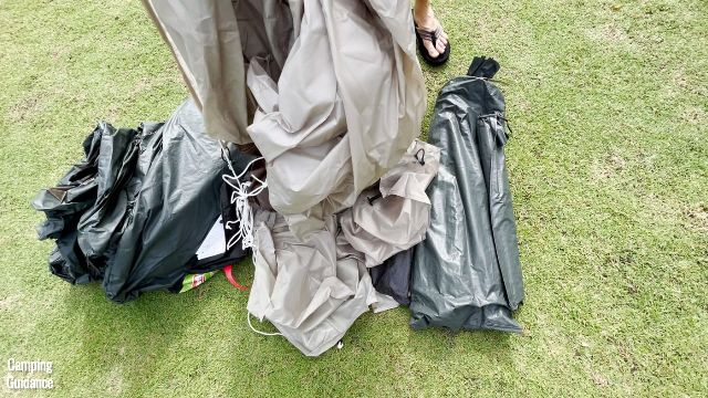 In this picture, you'll see the WeatherMaster 10-Person Tent's carry bag, tent body (left), rainfly with pre-attached guylines (middle), and steel poles in a pole bag (right).
