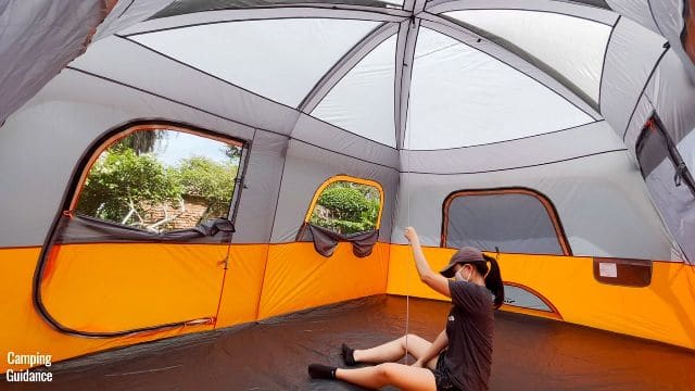 This is a picture of me using a measuring tape to measure the peak height of the Core 10-Person Straight Wall Cabin Tent (which is about 90 inches).