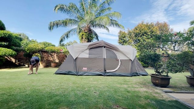 This is a picture of me setting up the guylines of the WeatherMaster 10-Person Tent. I had set up the entire tent on my own.