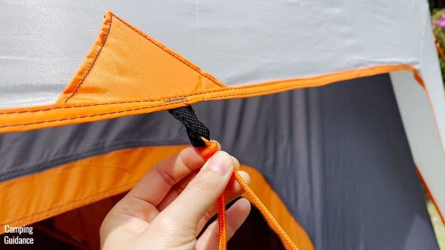 This is a picture of me holding one of the pre-attached guylines of the Core 10-Person Straight Wall Cabin Tent.