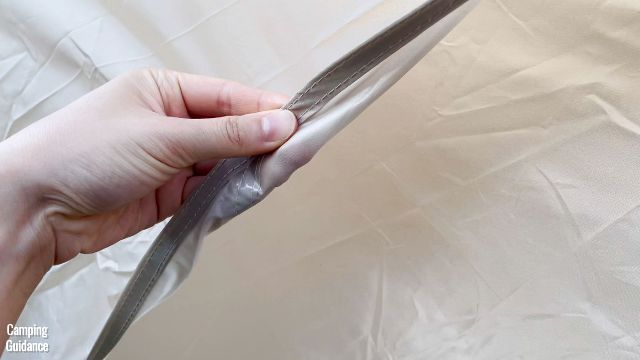 This is a picture of me touching the rainfly of the WeatherMaster 10-Person Tent, which is made of 75D polyester taffeta.