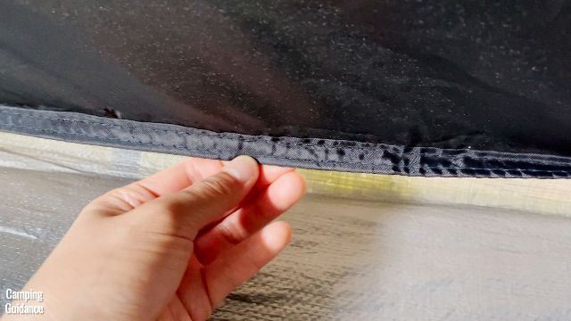 This is a picture of the inverted seam between the black tent fabric and the bathtub flooring of the Coleman 10-Person Instant Cabin Tent.