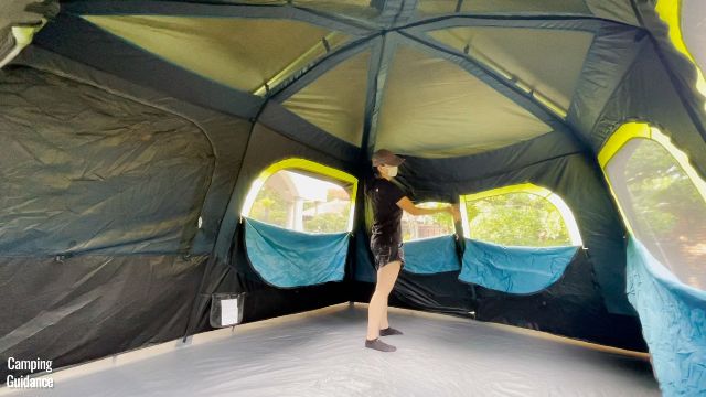 This is a picture of me reaching out to the side wall of the Coleman 10-Person Instant Cabin Tent, which I felt was droopier than it should have been.
