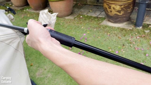 This is a picture of me inserting the top of one of the steel wall poles into the other end of the elbow connector of the Ozark Trail 10-Person Family Cabin Tent.