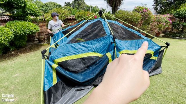 This is a picture of me pointing to the 2 roof poles at the back of the Coleman 10-Person Instant Cabin Tent that can be extended.