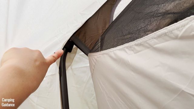 This is a picture of me pointing to one of the Velcro attachment of the rainfly, to be secured to the steel poles of the Coleman WeatherMaster 10-Person Tent.