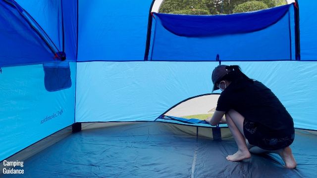 This is a picture of me unzipping the ground vent of the Columbia Mammoth Creek 10-Person Tent for some ventilation in the rain.