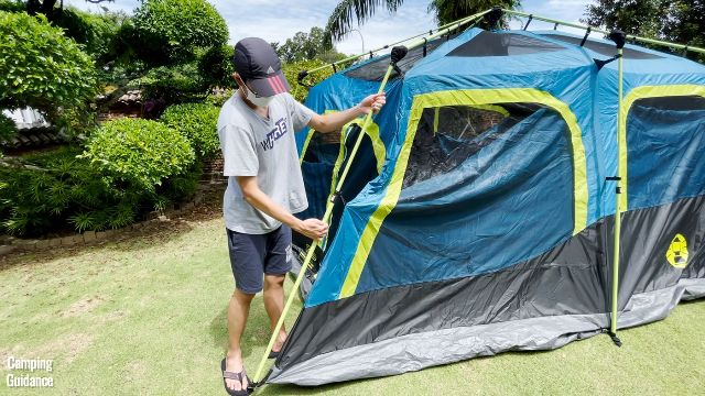 This is a picture of my brother extending the steel wall poles of the Coleman 10-Person Instant Cabin Tent.