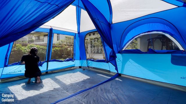This is a picture of me unzipping the mesh panels of the doors and windows of the Columbia Mammoth Creek 10-Person Tent. From left to right, we have the T-door, side door, and one of the pull-out windows.