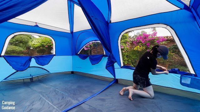 This is a picture of me opening up the windows of the Columbia Mammoth Creek 10-Person Tent. From left to right, we have the smallest window, tilted window, and the biggest window.